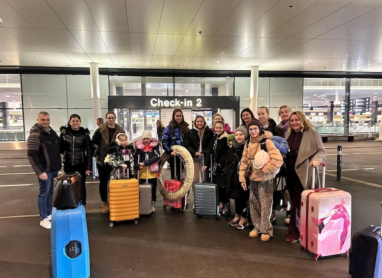 A group of people at an airport check-in area with luggage. 5