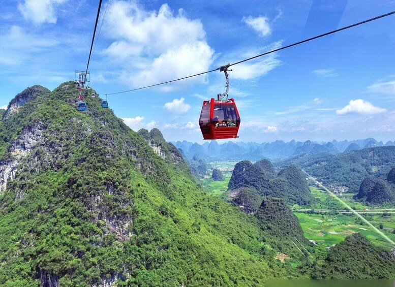 A cable car system in a mountainous area with lush greenery and a clear sky. 3