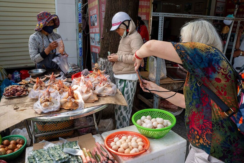 A street vendor selling seafood and eggs at a market stall. 2
