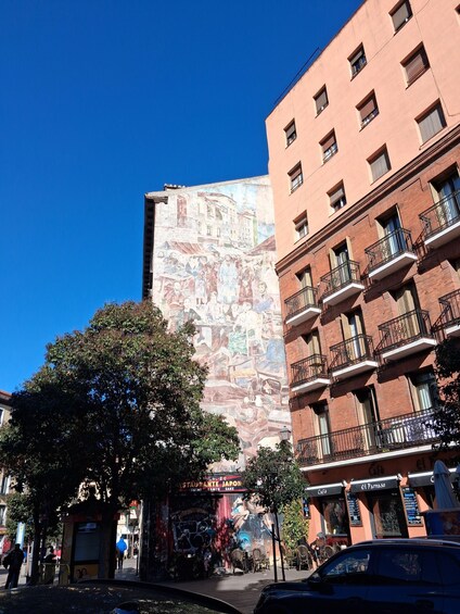 A building with a mural, a restaurant named 'RESTAURANTE JAPON,' and a cafe named 'El Parraso.' 2