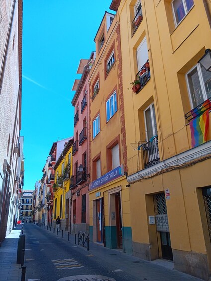 A narrow street lined with colorful buildings, a clear blue sky, and a sign for 'Centro de Estudios Castilla.' 3