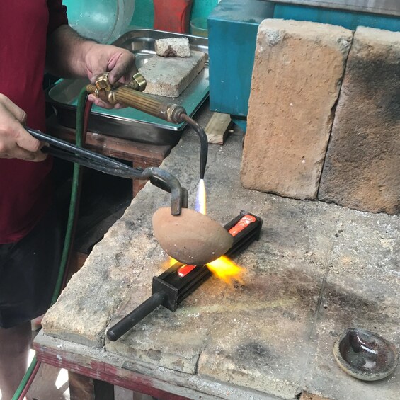 A person using a blowtorch on a metal object. 5