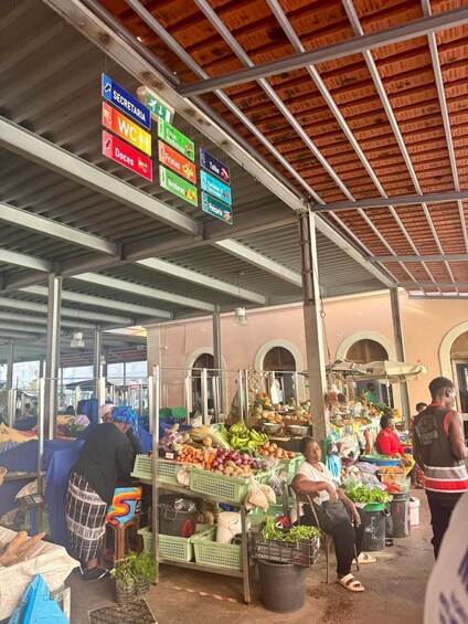 A market with signs for Secretariat, WC, Ervas Medicinales, Frutas, Talho, and Verdures. 2