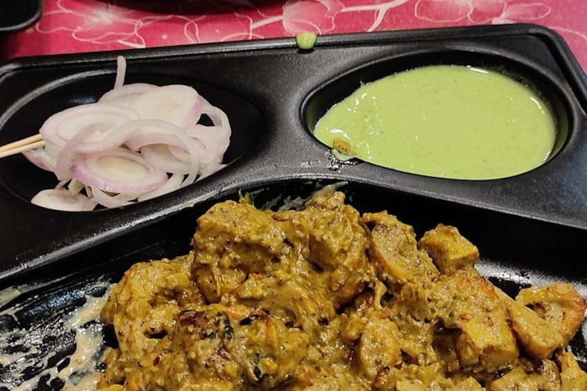 Un repas composé d’un plat en sauce à base de curry, d’oignons coupés en tranches et d’une sauce verte. 4