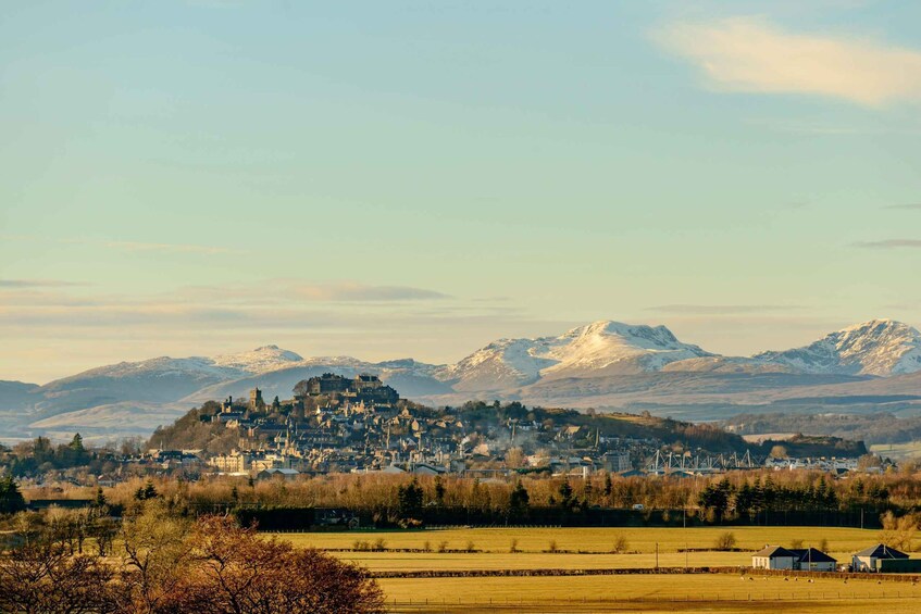 A town nestled in a valley with snow-capped mountains in the background. 5