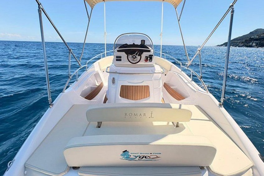 A boat with a 'ROMAR' name on the bow, a 'Vogue' logo, and a clear blue sea in the background. 2