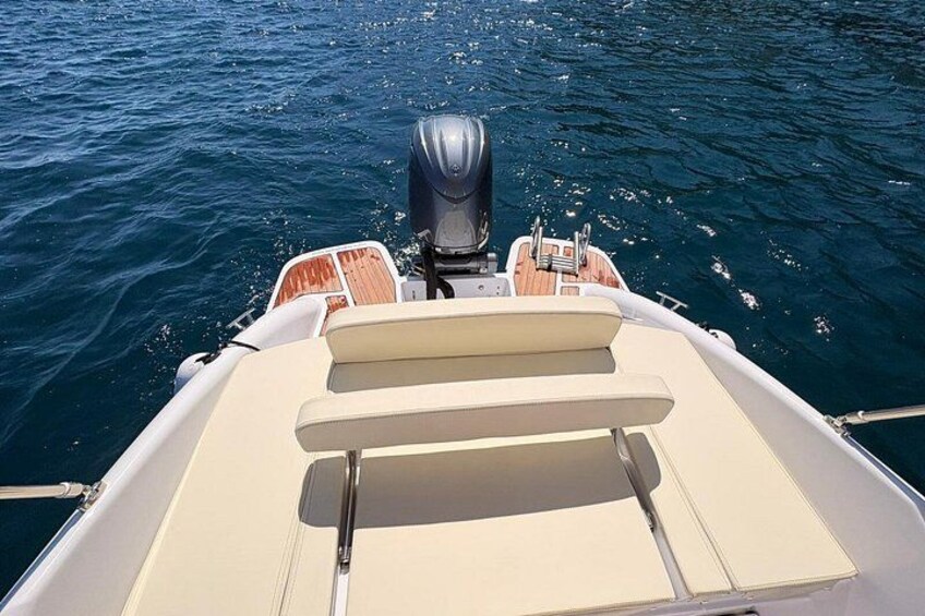 A boat's stern with a motor and seating area. 5