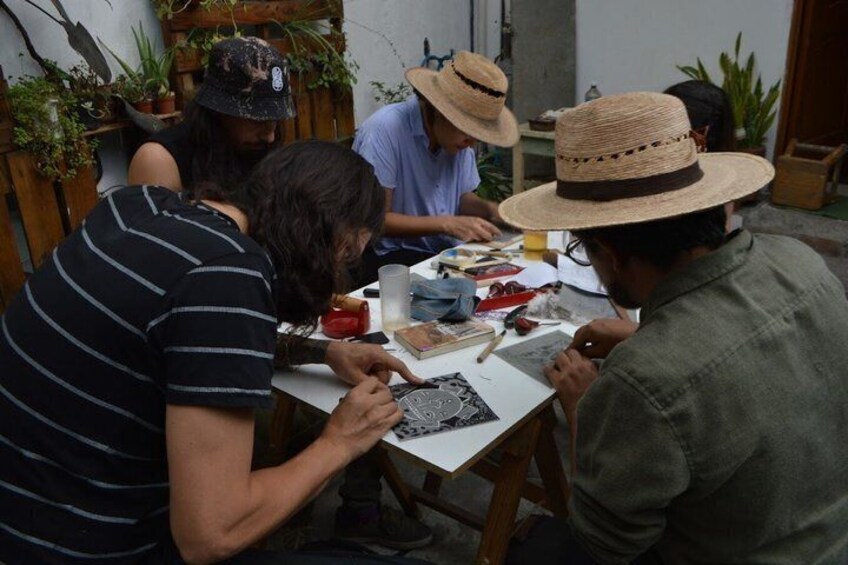 People sitting at a table with drawing materials, engaged in a creative activity. 2