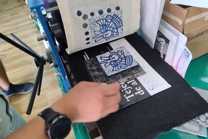A person using a machine to cut a design from a piece of material. 2