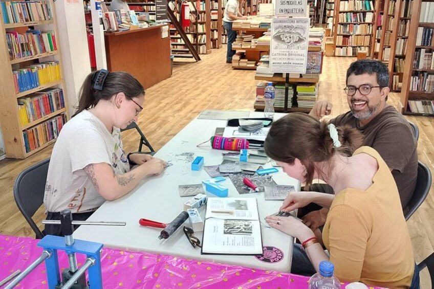 A library with bookshelves, a table with drawing materials, and people engaged in drawing activities. 4