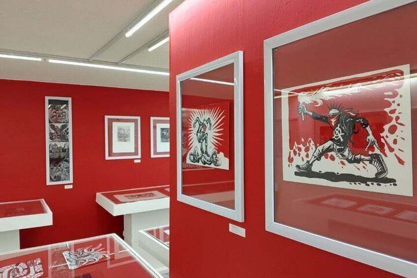 An art gallery with red walls and framed artworks. 5