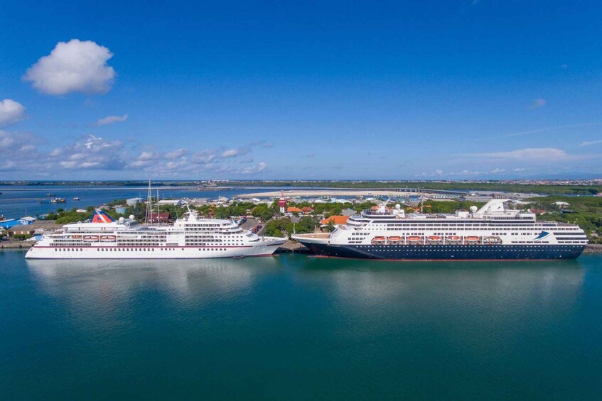 A cruise ship docked at a port with a clear blue sky and calm sea. 1