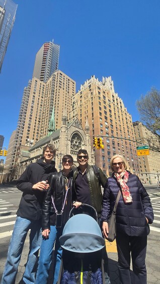 A group of people standing in front of a historic building with a clock tower and modern high-rise buildings in the background. 1