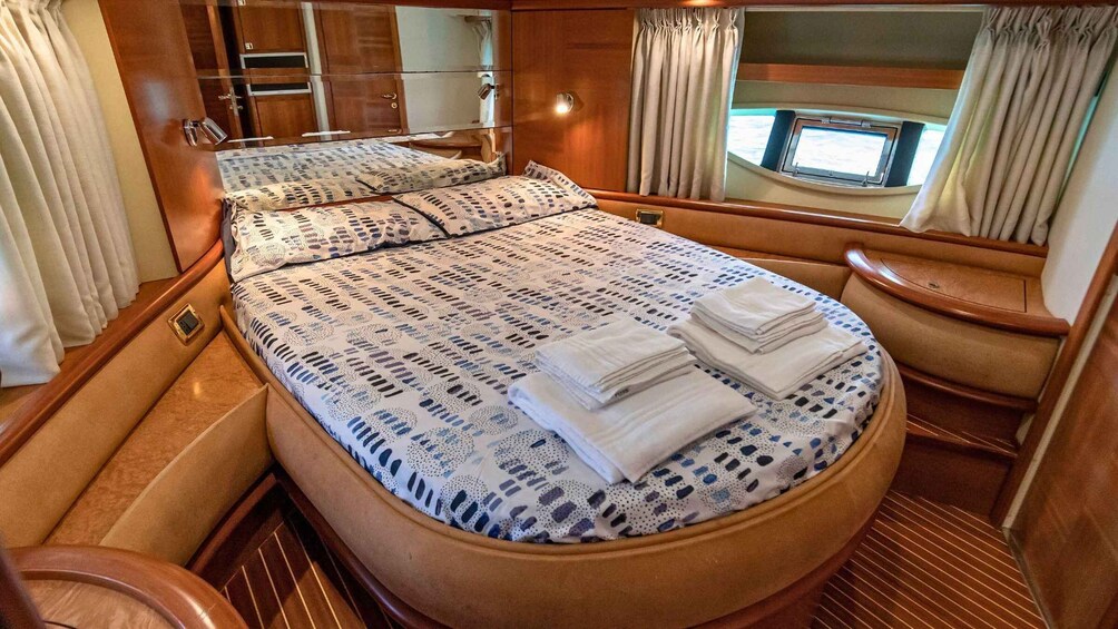 A cozy interior of a motorhome with a bed, a small table, and a window. 2