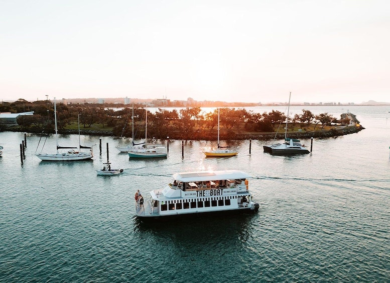 A river with several boats, including a white tour boat in the foreground. 3