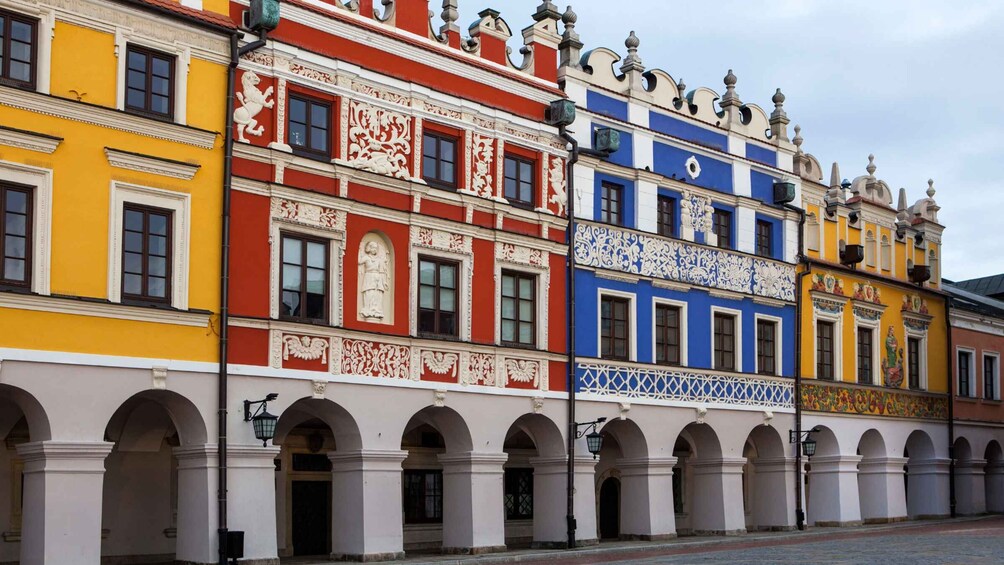 A row of colorful buildings with ornate facades and arched windows. 1