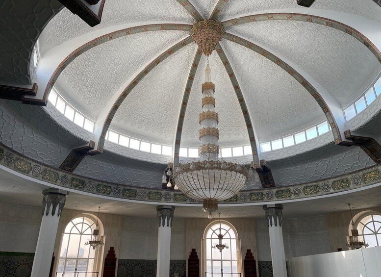 A grand hall with a domed ceiling, ornate chandeliers, and intricate tile work. 4