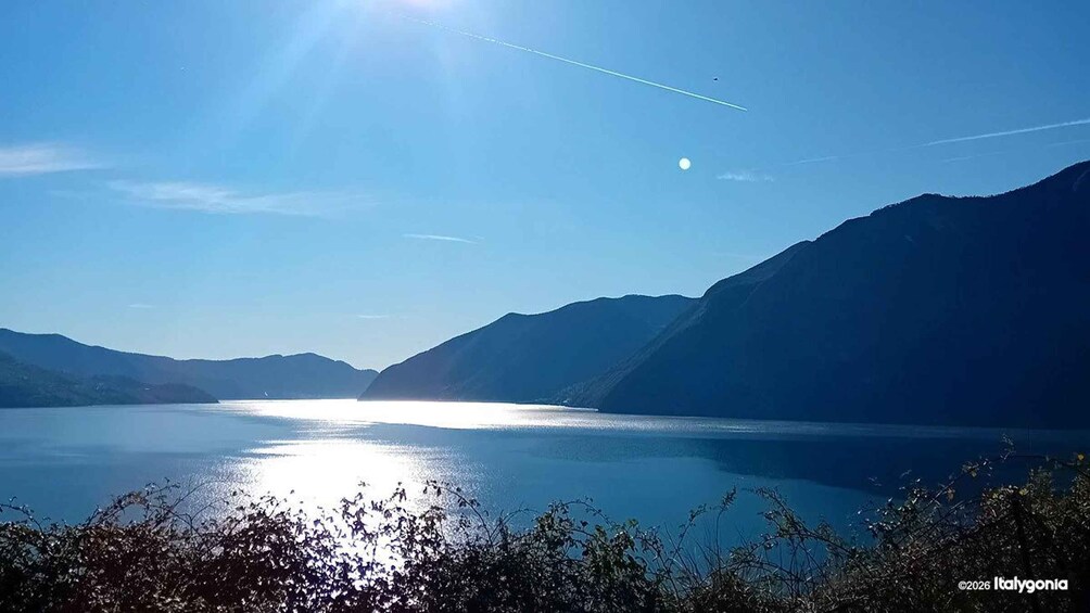 A calm lake with mountains in the background and a clear sky. 5