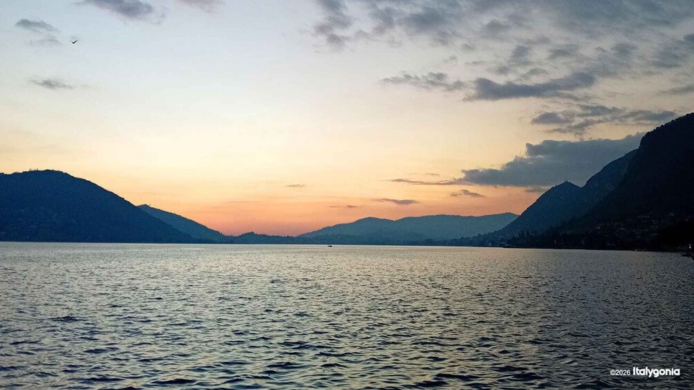 A calm lake with mountains in the background during sunset. 1