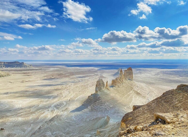 A vast desert landscape with prominent rock formations under a clear blue sky. 1