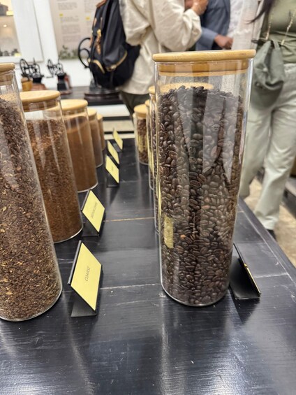 A display of coffee beans in glass jars with labels. 3