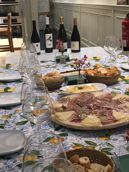 A table set with various dishes, wine bottles, and glasses. 3