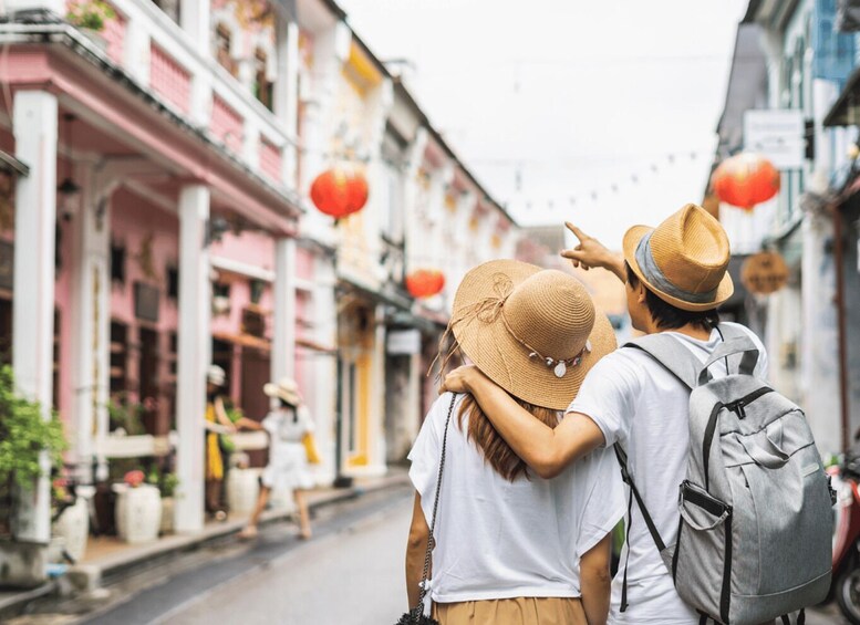 A couple embracing on a street with traditional buildings and red lanterns. 4