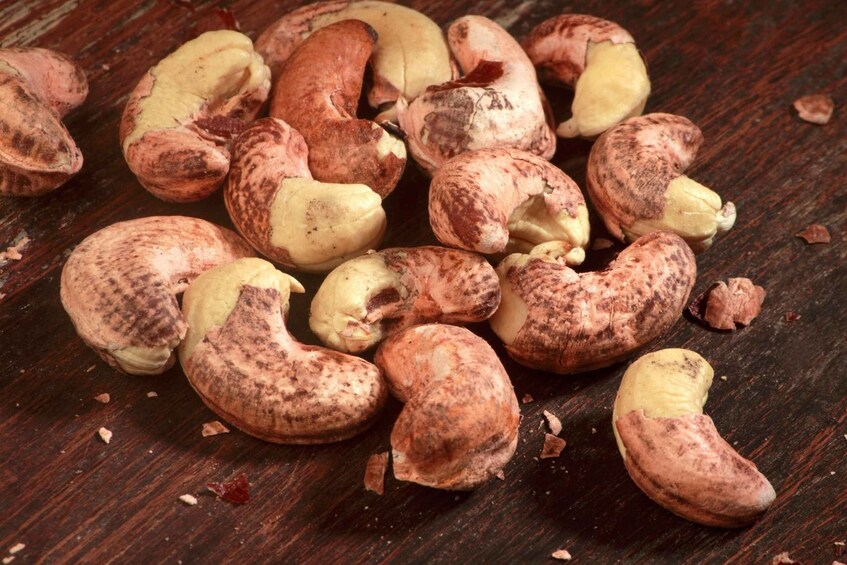Cashew nuts scattered on a wooden surface. 2