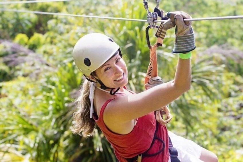 A person ziplining through a forested area. 1