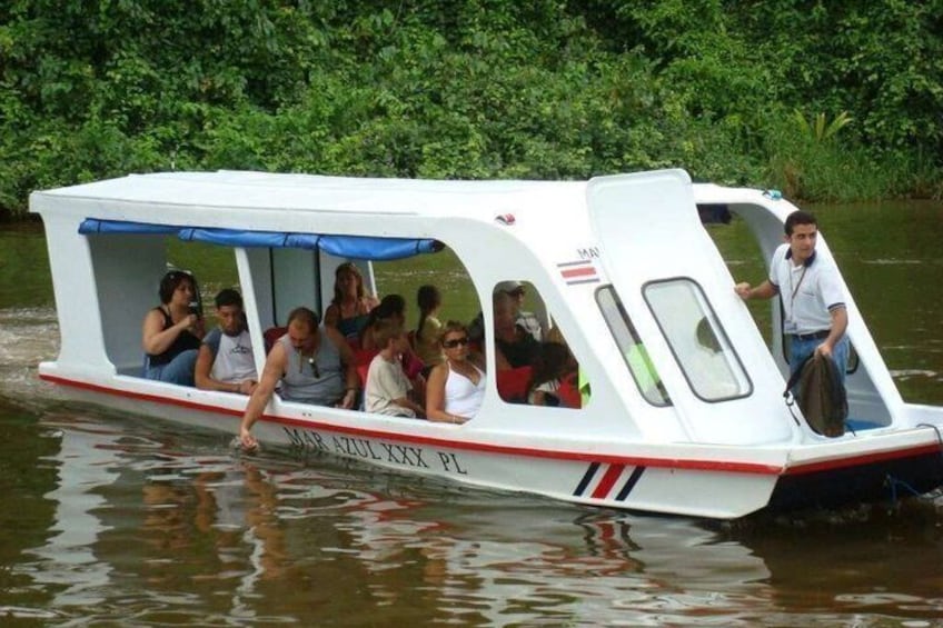 A white boat with red and blue stripes, labeled 'MAR AZUL XXX PL,' on a river surrounded by greenery. 2