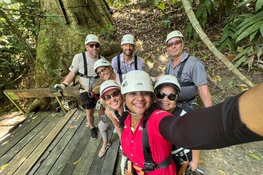A group of people on a wooden bridge in a forested area. 4