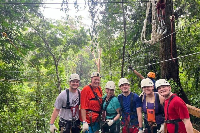 A group of people on a zipline adventure in a forested area. 3