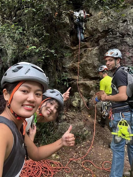 A group of people engaged in rock climbing, with ropes and climbing gear visible. 1