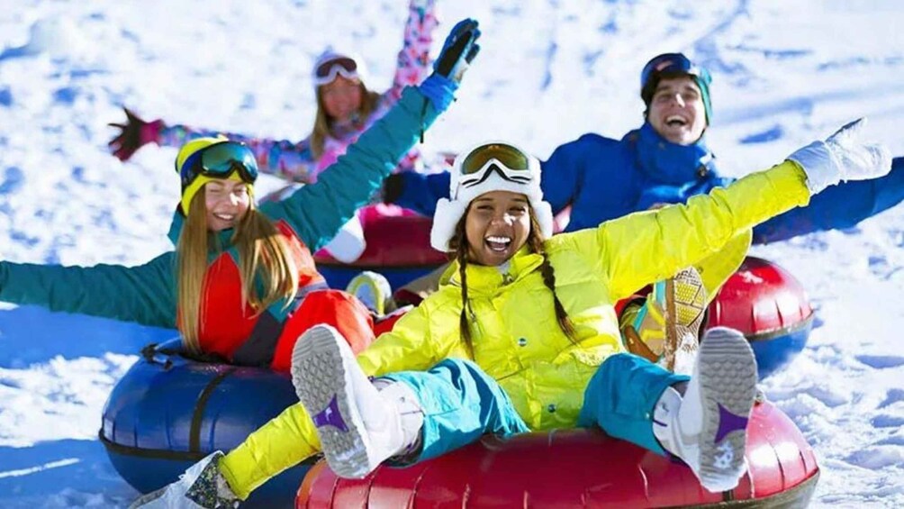 People on snow tubes at a snowy slope. 1