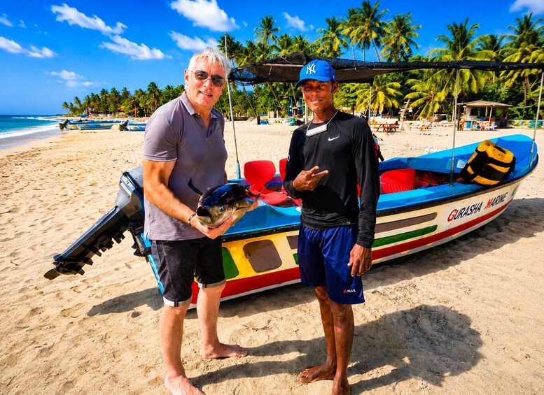 Two men on a beach with a colorful boat named 'GURASHA MARINE' and a jet ski in the background. 3