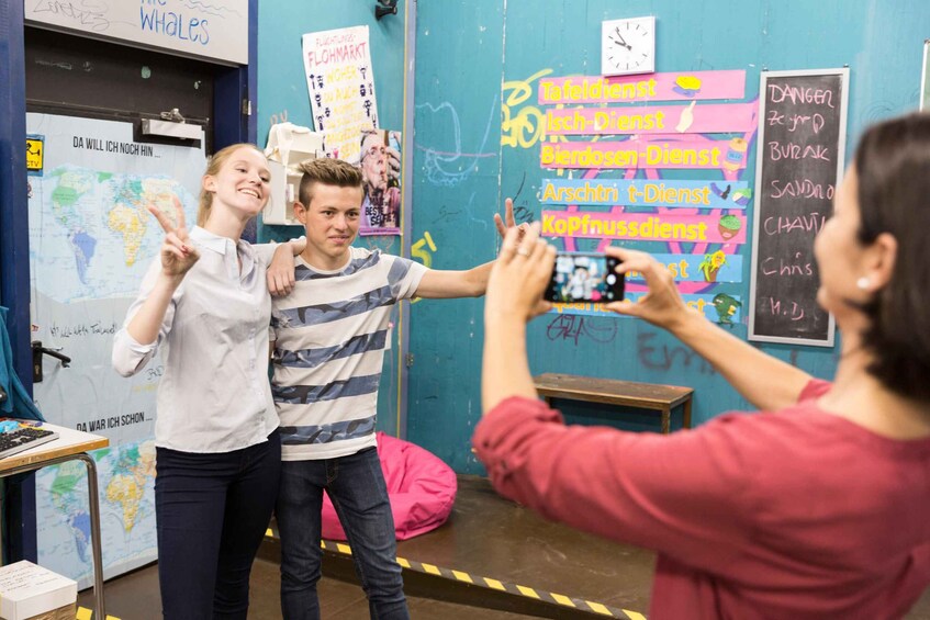 A classroom with a world map, a chalkboard with service categories, and a clock. 3