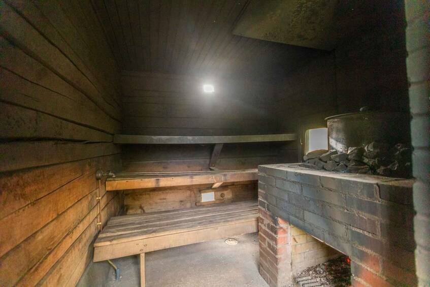 A wooden interior with a brick fireplace, a metal container, and a light fixture. 5