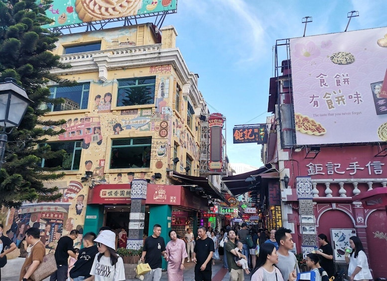 A bustling street with colorful buildings, a crowd of people, and various signs and advertisements. 3
