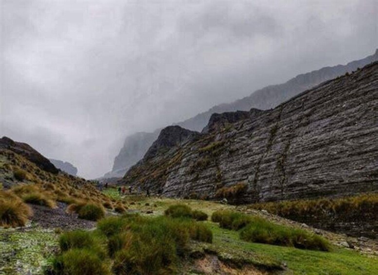 A rugged mountain landscape with steep cliffs and sparse vegetation. 2