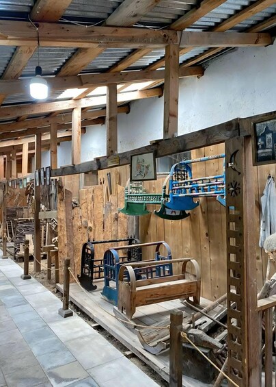 A wooden interior with machinery and tools, including a blue machine and wooden structures. 2