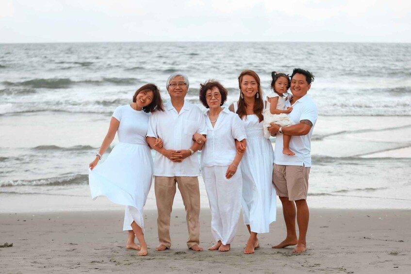 A family on a beach with the ocean in the background. 4