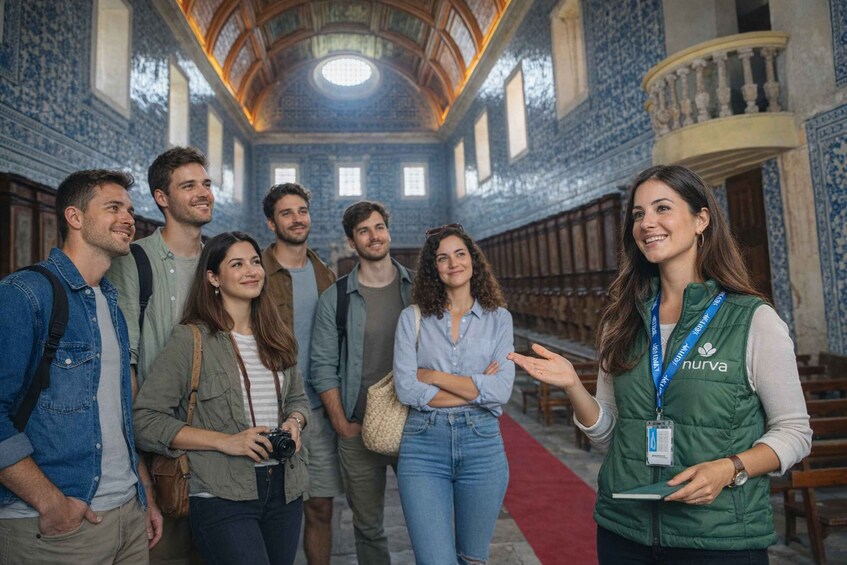 A group of people inside a building with blue and white patterned walls and a red carpet. 2