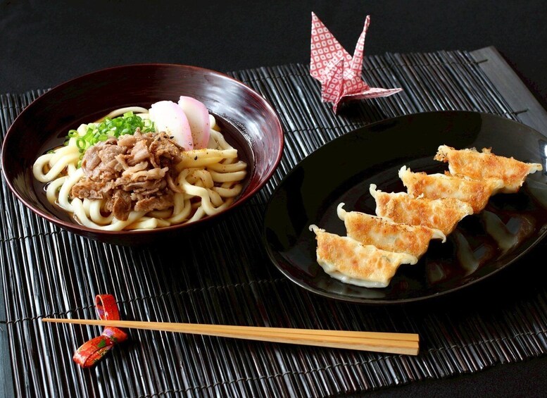 A bowl of ramen with meat and a plate of tempura. 1
