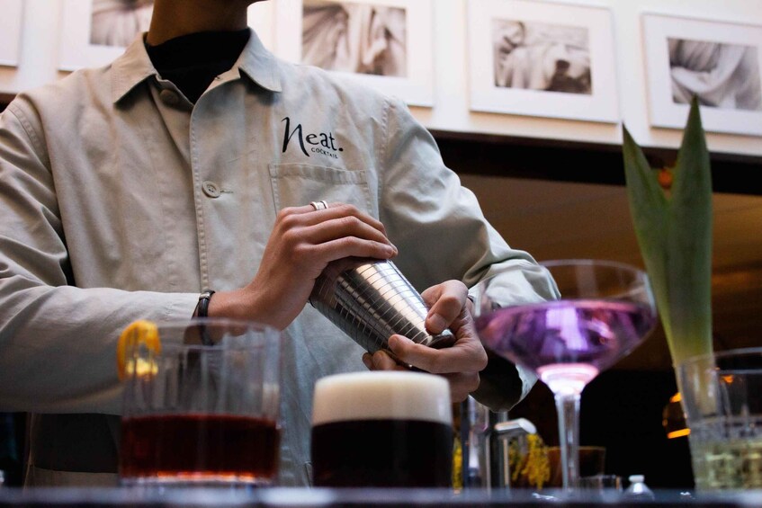A bartender preparing a cocktail with a shaker. 1