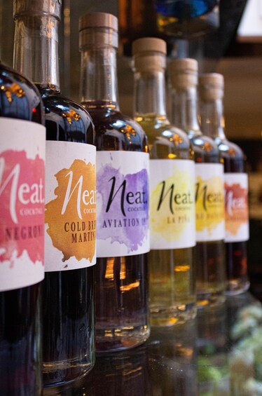 A row of bottles with labels, each featuring a different color and text. 4