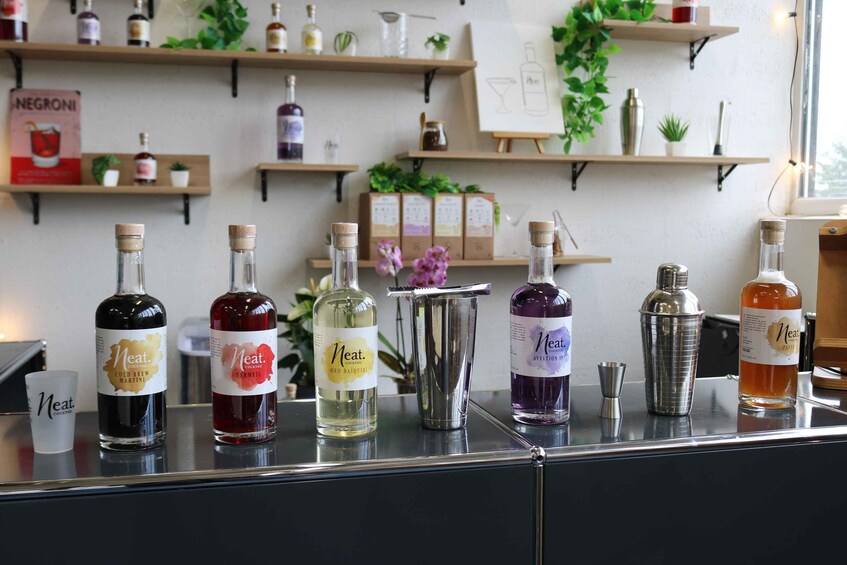 A bar counter with various bottles of alcohol, a martini glass, and a cocktail shaker. 3