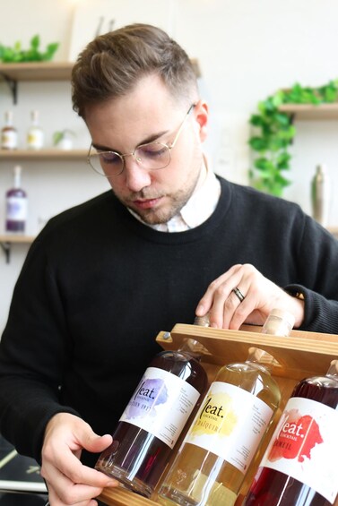 A person holding a wooden tray with bottles labeled 'Heat.' 5