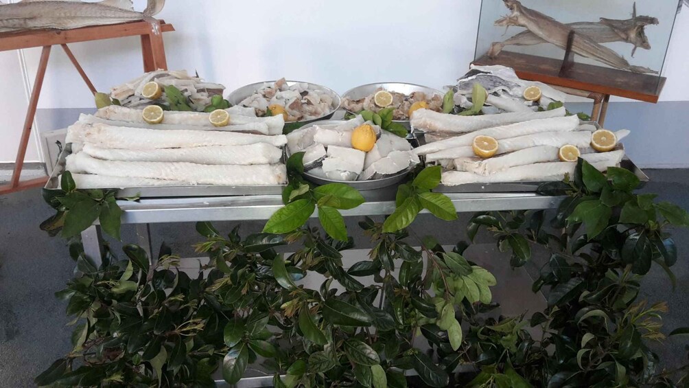 A display of fish on ice with lemon slices and green leaves. 1