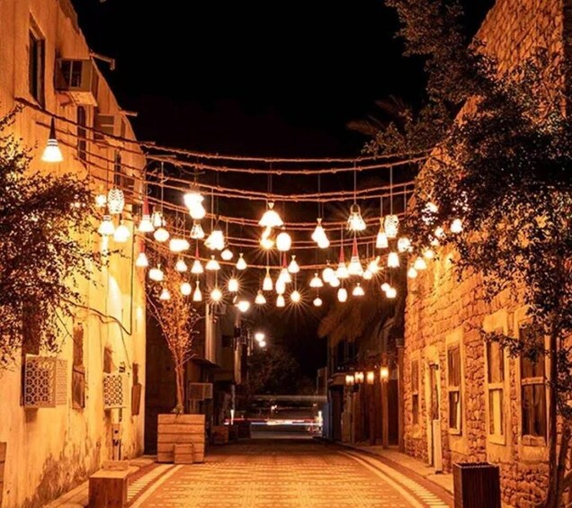 A street at night with string lights and buildings. 5