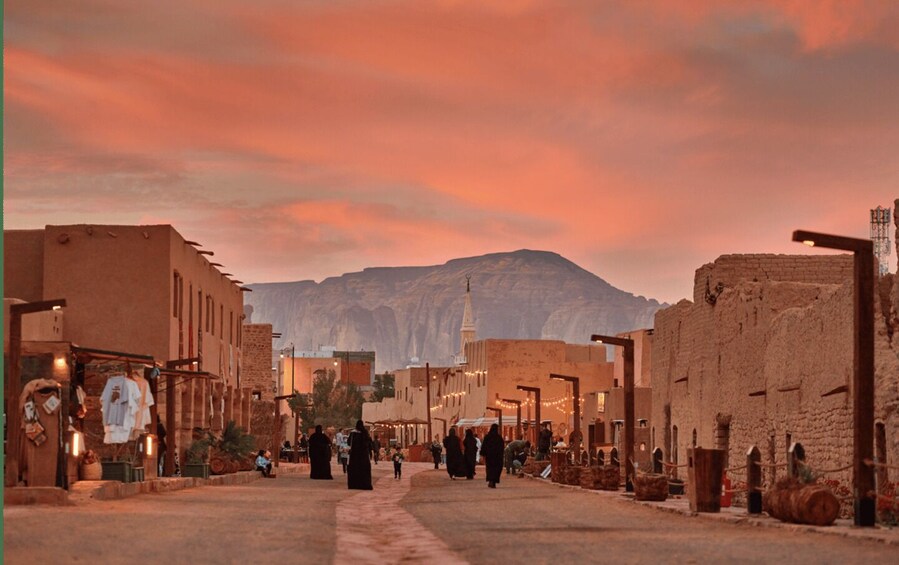 A desert town with traditional buildings and a mosque, set against a backdrop of mountains. 4